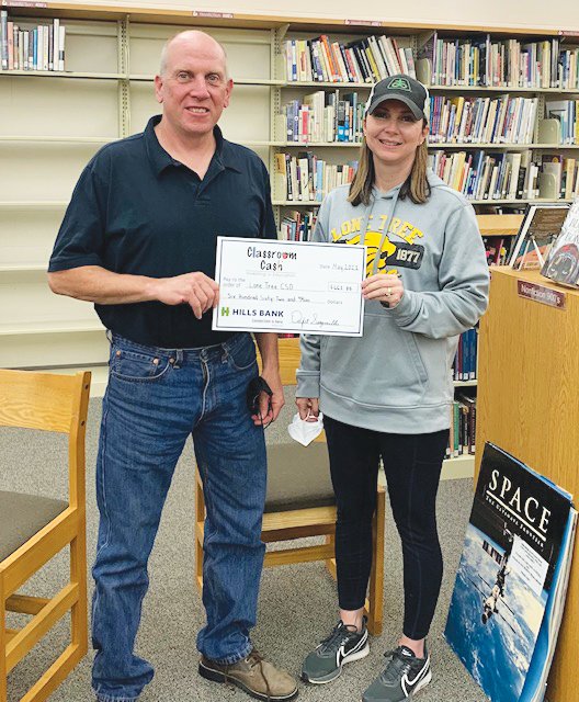 Lone Tree school board vice president Mike Waldschmidt, left, and president Christina Magruder accept a Classroom Cash check for $662.85.